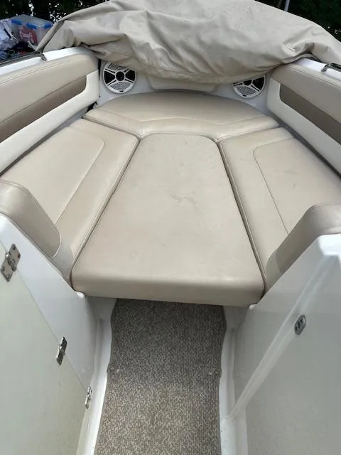 Slide: The Image of 2011 Chaparral 216 SSi boat interior with beige seating and covered bow area. - 9