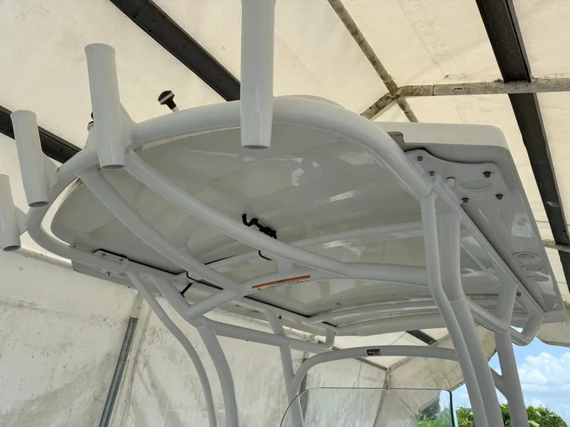 Slide: The Image of 2020 Wellcraft 222 Fisherman boat with T-top and rod holders in a covered area. - 17