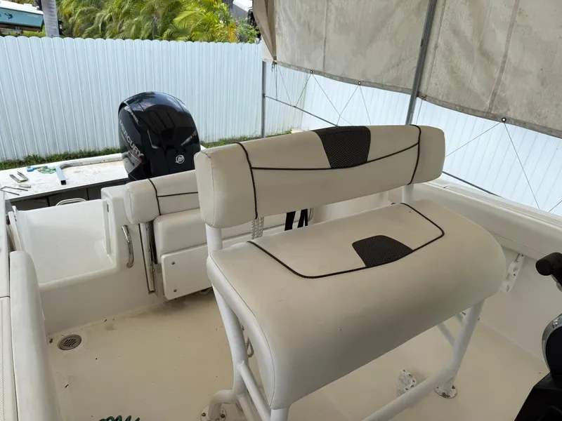Slide: The Image of 2020 Wellcraft 222 Fisherman boat interior with cushioned seating and outboard motor. - 9