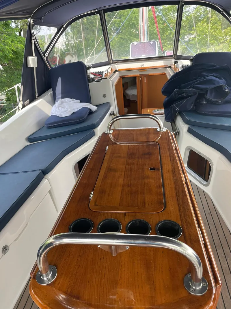 Slide: The Image of 2008 Jeanneau Sun Odyssey 45 DS cockpit with wooden table and cushioned seating. - 13