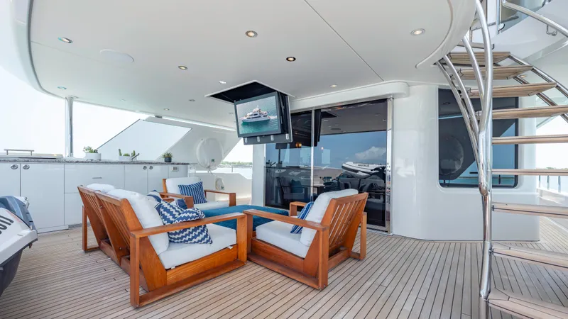 Slide: The Image of Luxurious 2014 Westport 40M yacht deck with wooden seating, TV, and spiral staircase. - 44
