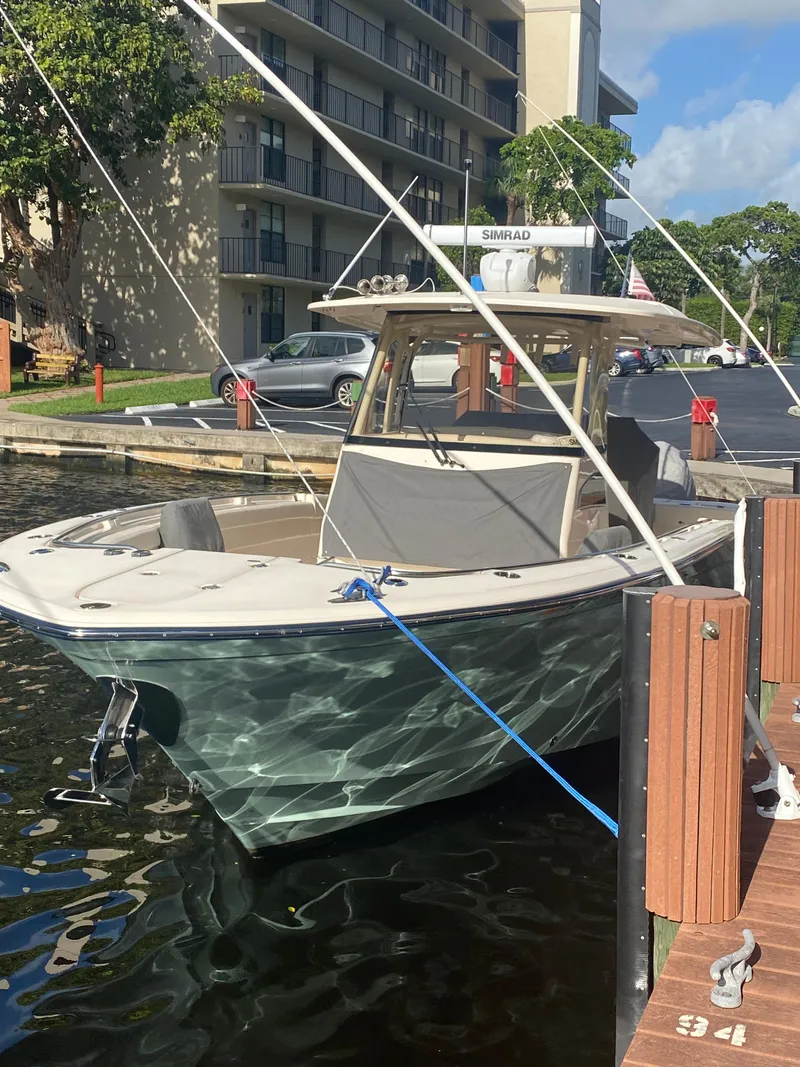 Slide: The Image of 2024 Grady-White Canyon 326 boat docked near waterfront building. - 5