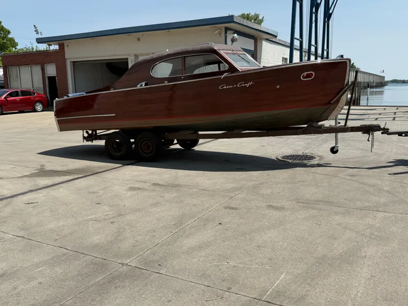 Slide: The Image of 1950 Chris-Craft 22' Custom Sedan boat on trailer near waterfront building. - 2