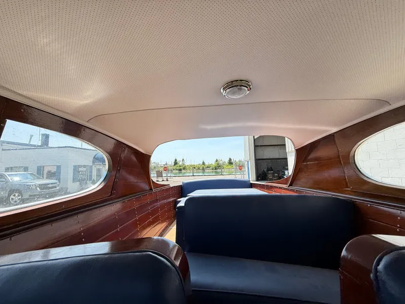 Slide: The Image of Interior of a 1950 Chris-Craft 22' Custom Sedan with wooden panels and blue seating. - 9
