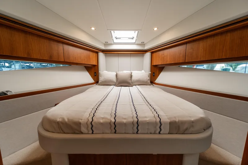 Slide: The Image of Luxurious bedroom interior of 2018 Riviera 5400 Sport Yacht with elegant wood finishes. - 11