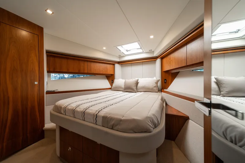Slide: The Image of Luxurious bedroom interior of 2018 Riviera 5400 Sport Yacht with elegant wood finishes. - 13