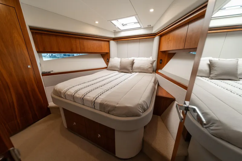 Slide: The Image of Luxurious bedroom interior of 2018 Riviera 5400 Sport Yacht with elegant wood finishes. - 14