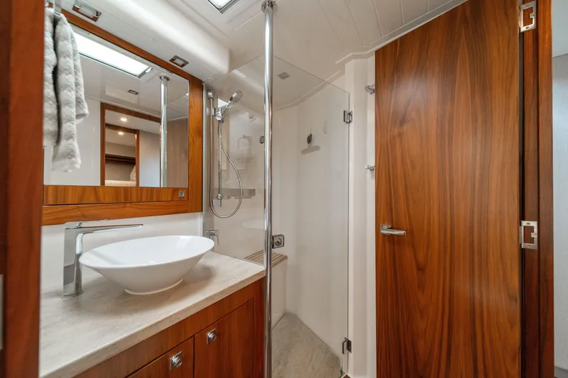 Slide: The Image of Luxurious bathroom in 2018 Riviera 5400 Sport Yacht with modern fixtures and wood accents. - 15