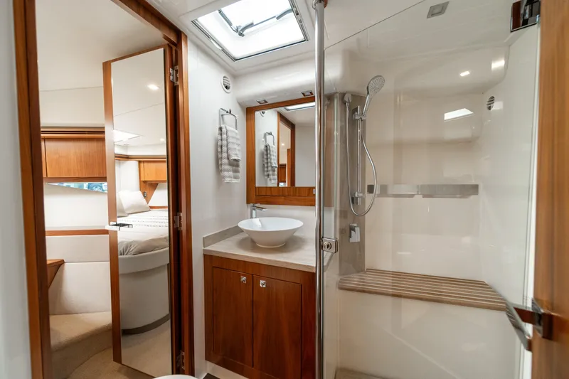 Slide: The Image of Luxurious bathroom interior of 2018 Riviera 5400 Sport Yacht with modern fixtures and wooden accents. - 16