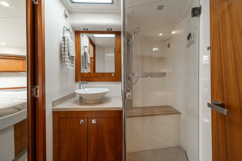 Slide: The Image of Luxurious bathroom in 2018 Riviera 5400 Sport Yacht with modern fixtures and wooden accents. - 17