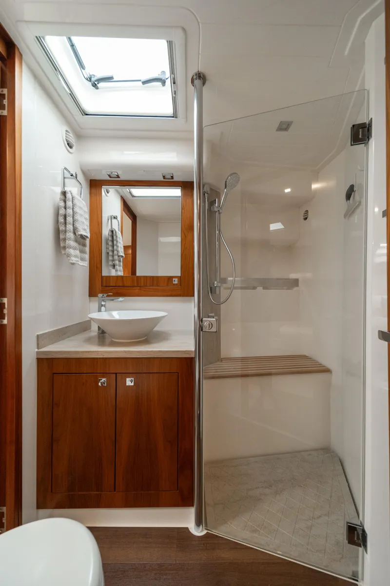Slide: The Image of Luxurious bathroom in 2018 Riviera 5400 Sport Yacht with modern fixtures and wooden cabinetry. - 18