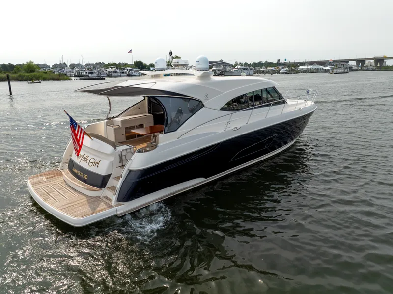 Slide: The Image of 2018 Riviera 5400 Sport Yacht cruising on a calm waterway, rear view. - 2