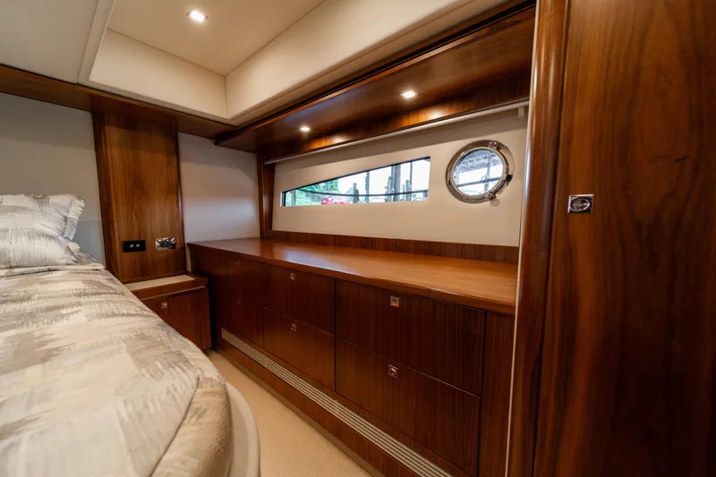 Slide: The Image of Luxurious interior of 2018 Riviera 5400 Sport Yacht with wooden cabinetry and porthole window. - 23