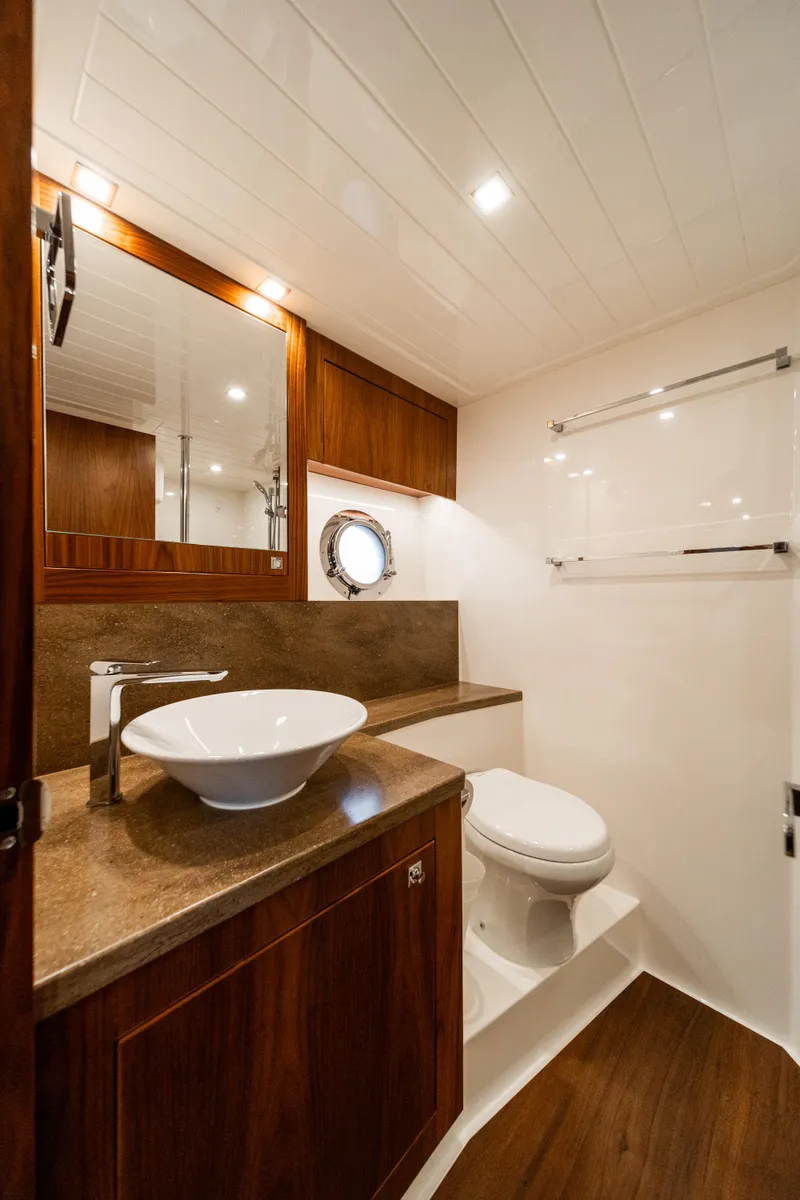 Slide: The Image of Luxurious bathroom in 2018 Riviera 5400 Sport Yacht with modern fixtures and elegant wood accents. - 25