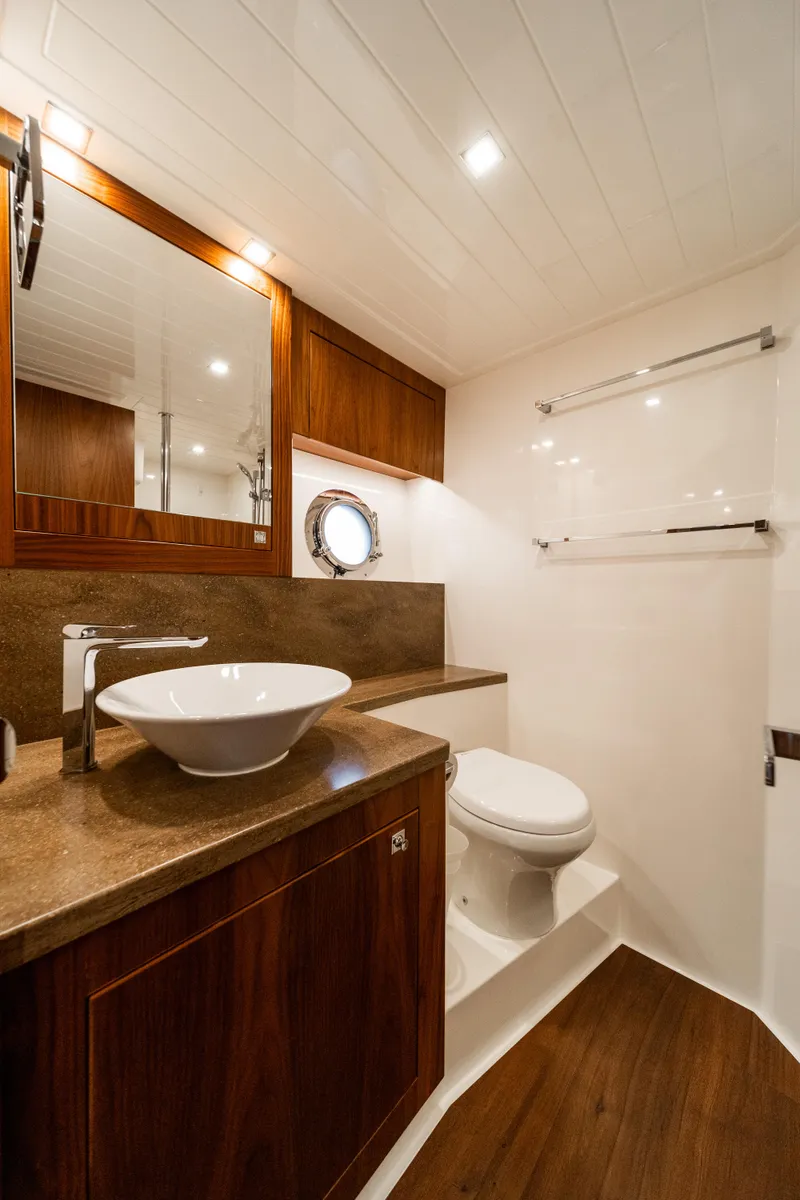 Slide: The Image of Luxurious bathroom in 2018 Riviera 5400 Sport Yacht with modern fixtures and wood accents. - 28