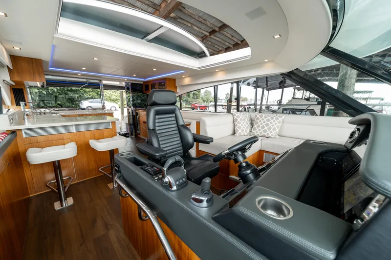 Slide: The Image of 2018 Riviera 5400 Sport Yacht interior with modern helm, seating, and bar area. - 30