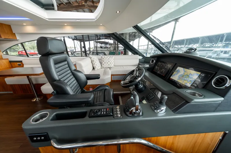 Slide: The Image of 2018 Riviera 5400 Sport Yacht interior with modern helm, leather seating, and navigation displays. - 31
