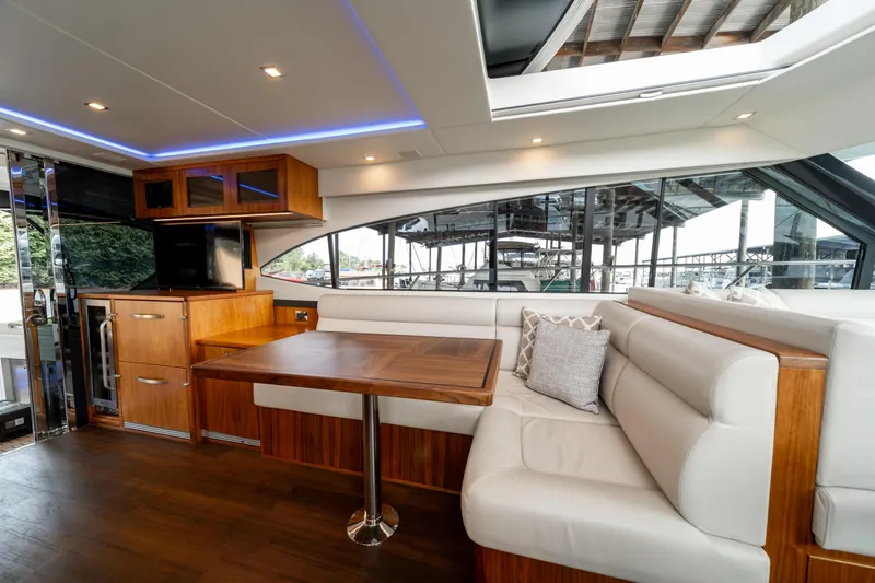 Slide: The Image of Luxurious interior of 2018 Riviera 5400 Sport Yacht with elegant seating and wooden table. - 35