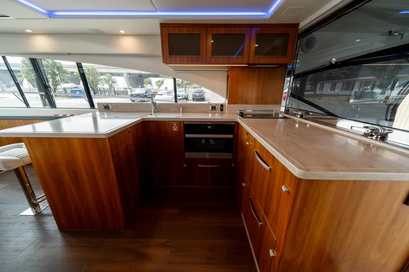 Slide: The Image of Luxurious kitchen interior of 2018 Riviera 5400 Sport Yacht with wood cabinetry and modern appliances. - 39