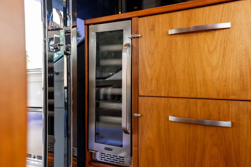 Slide: The Image of Luxurious wooden cabinetry and wine cooler in 2018 Riviera 5400 Sport Yacht interior. - 41