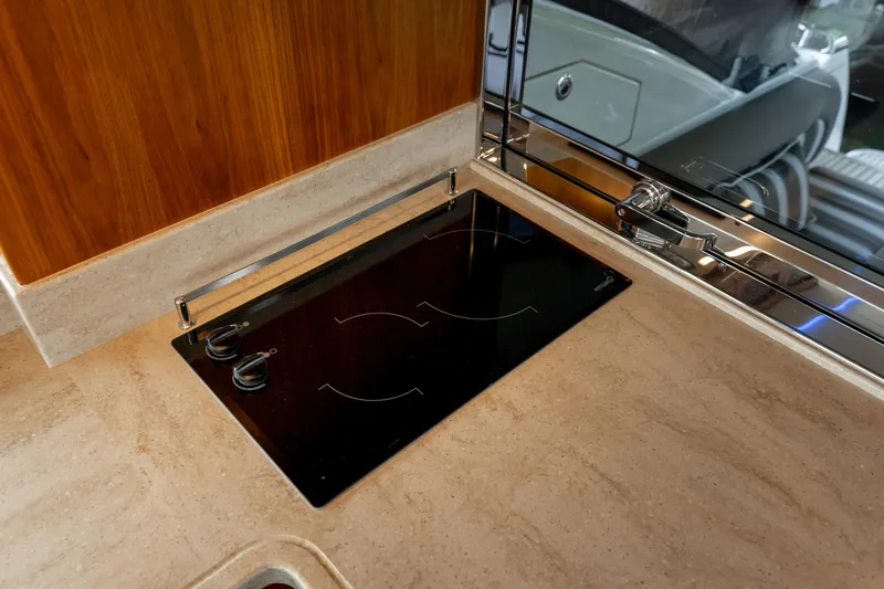 Slide: The Image of Modern kitchen area in 2018 Riviera 5400 Sport Yacht with sleek cooktop. - 43