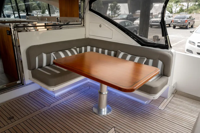Slide: The Image of 2018 Riviera 5400 Sport Yacht interior with elegant seating and wooden table. - 47