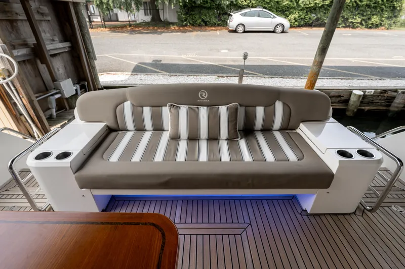 Slide: The Image of 2018 Riviera 5400 Sport Yacht interior with striped seating and cup holders. - 48