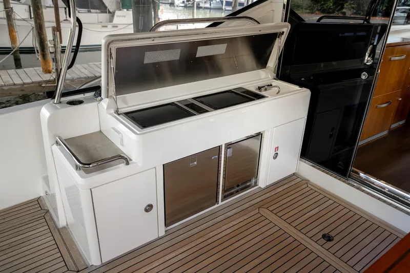 Slide: The Image of 2018 Riviera 5400 Sport Yacht outdoor kitchen with grill and storage on teak deck. - 49