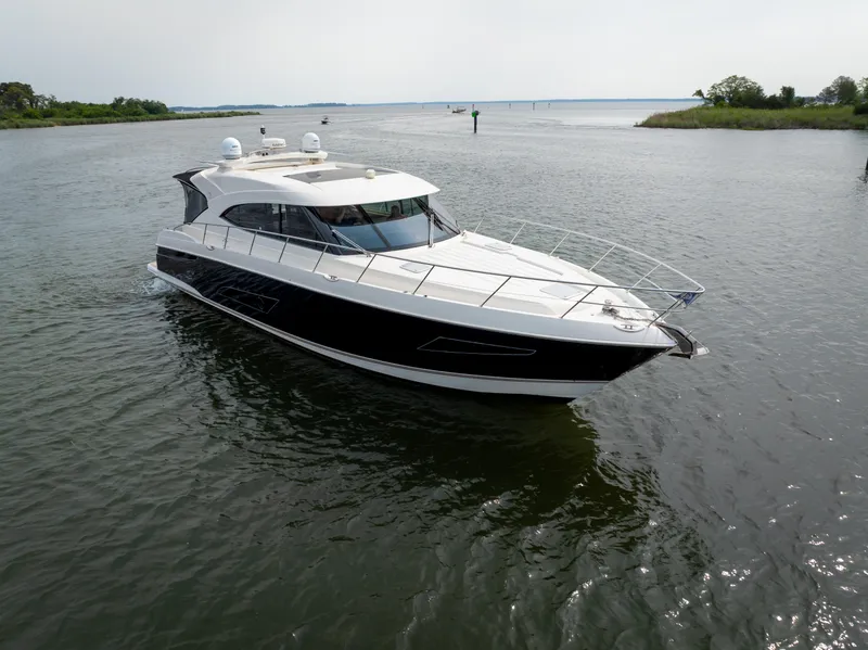 Slide: The Image of 2018 Riviera 5400 Sport Yacht cruising on a calm waterway. - 9