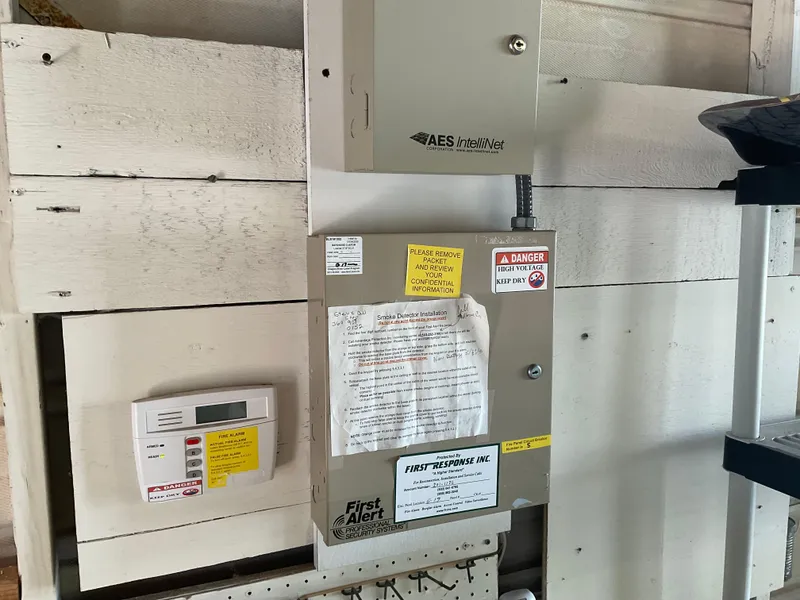 Slide: The Image of Electrical control panel in a 1980 custom boathouse with safety labels and instructions. - 11