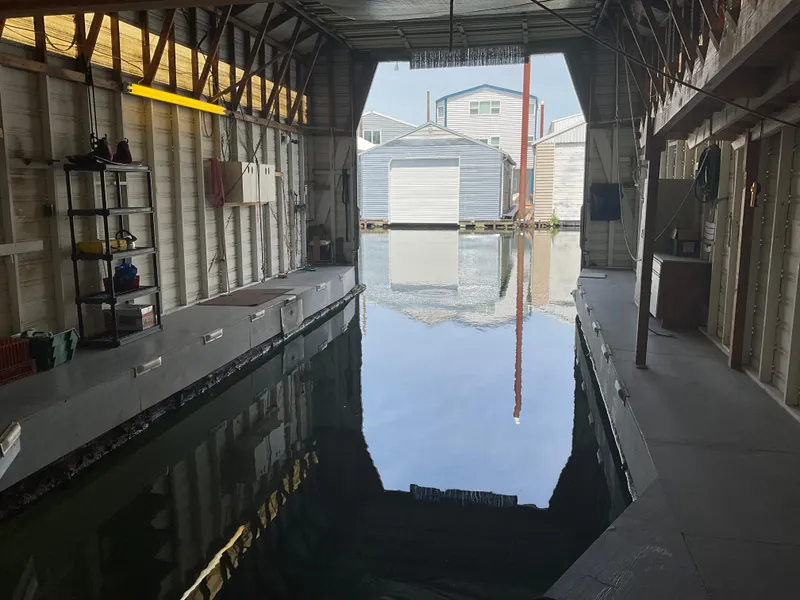 Slide: The Image of Interior of a 1980 custom boathouse with waterway and storage shelves. - 5