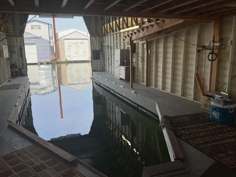 Slide: The Image of Interior of a 1980 custom boathouse with water channel and wooden structure. - 6