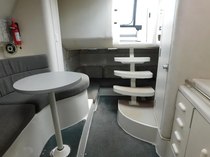 Slide: The Image of 1991 Chris-Craft 302 Crowne cabin interior with seating, table, and stairs. - 15