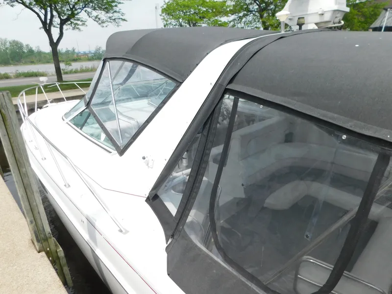 Slide: The Image of 1991 Chris-Craft 302 Crowne boat docked with black canopy and white exterior. - 7