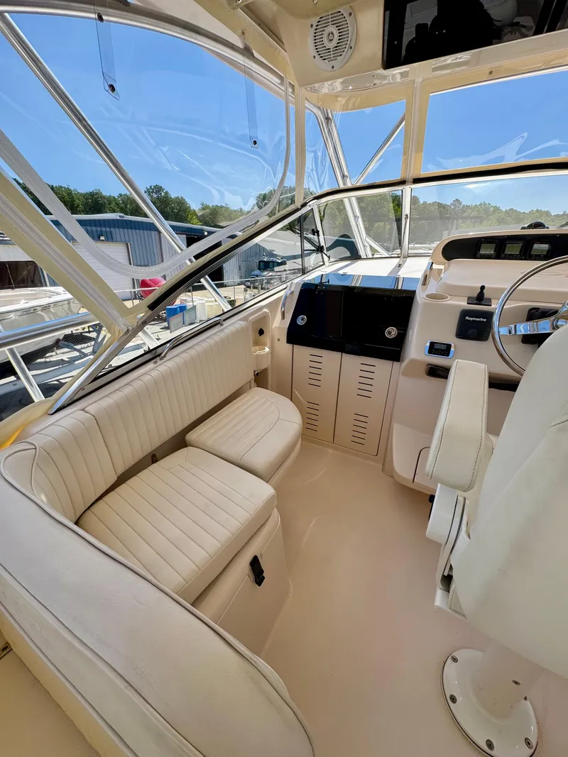 Slide: The Image of 2007 Grady-White Express 330 boat interior with seating and helm, featuring clear windows. - 6