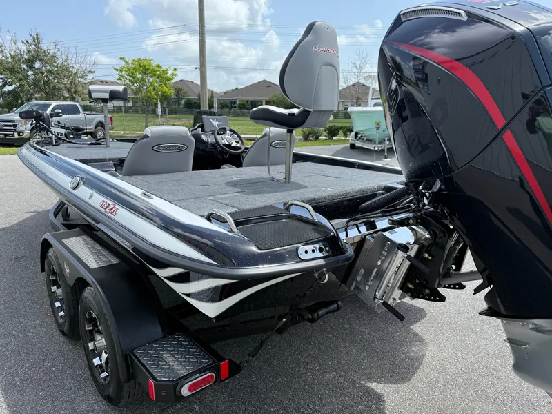 Slide: The Image of 2026 Phoenix 819 ZXL boat with powerful outboard motor, sleek design, and dual-axle trailer. - 12