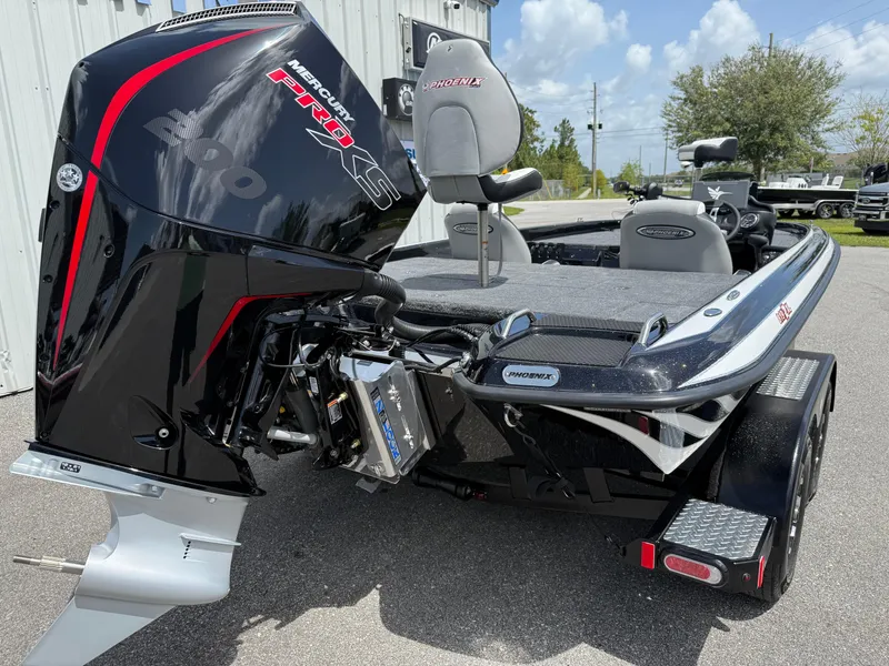 Slide: The Image of 2026 Phoenix 819 ZXL boat with powerful Mercury Pro XS engine, parked outdoors. - 13
