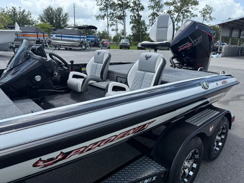 Slide: The Image of 2026 Phoenix 819 ZXL boat with dual seats and powerful outboard motor in a marina setting. - 4