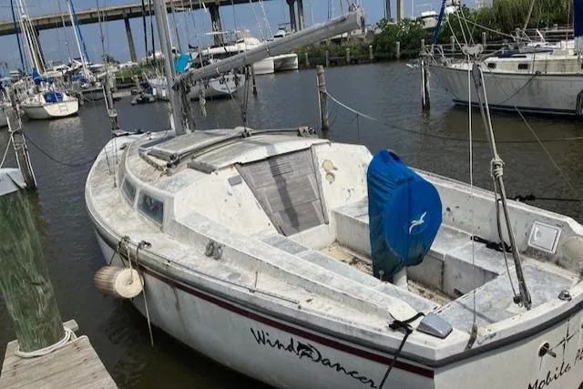 Slide: The Image of 1977 Catalina 30 Tall Rig sailboat docked in a marina, showing weathered exterior. - 3