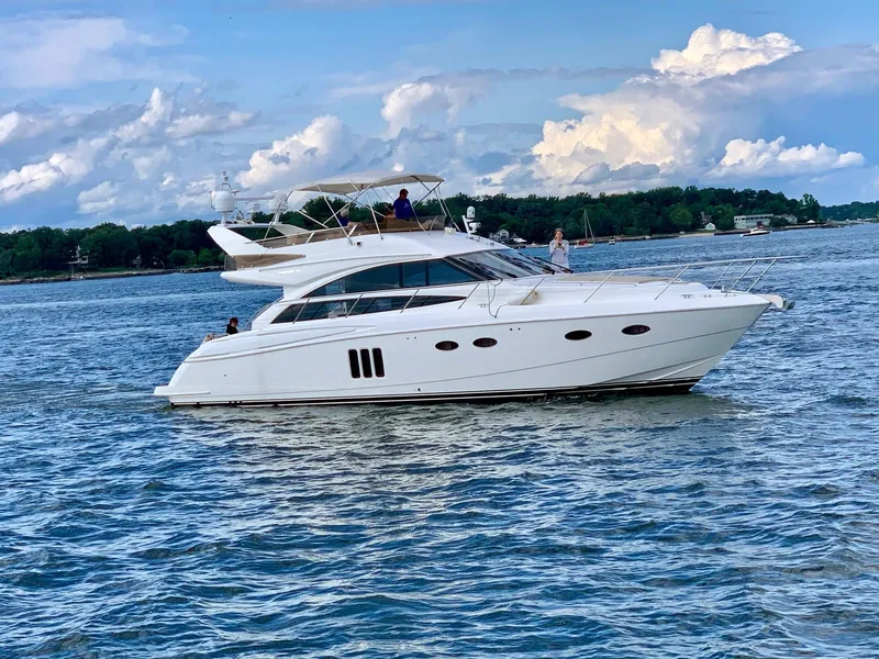 The Image of Luxury Princess F54 yacht cruising on a serene lake under a partly cloudy sky. - 0