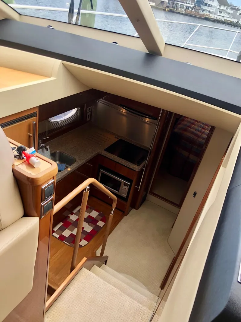Slide: The Image of Interior view of 2009 Princess F54 yacht, featuring a compact kitchen and staircase. - 16