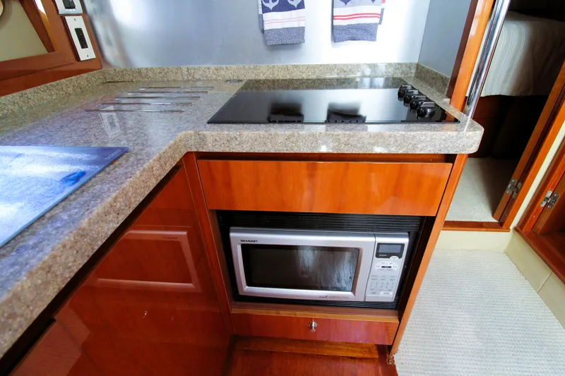 Slide: The Image of Modern yacht kitchen with stove, microwave, and wooden cabinetry in a 2009 Princess F54. - 18