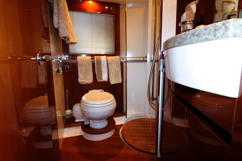 Slide: The Image of Luxurious yacht bathroom with wooden accents, featuring a toilet, shower, and elegant fixtures. - 19