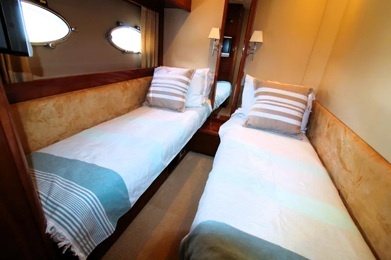 Slide: The Image of Twin beds in a 2009 Princess F54 yacht cabin with striped bedding. - 29