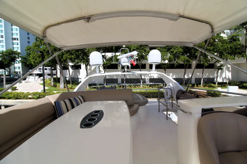 Slide: The Image of Luxurious 2009 Princess F54 yacht deck with seating and table, docked near greenery. - 37