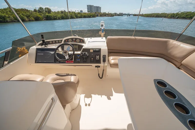 Slide: The Image of Luxurious 2009 Princess F54 yacht cockpit with modern controls and scenic waterway view. - 54