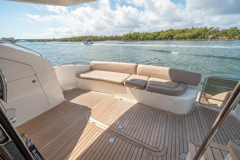 Slide: The Image of Luxurious 2009 Princess F54 yacht deck with seating, overlooking serene waters and lush greenery. - 79