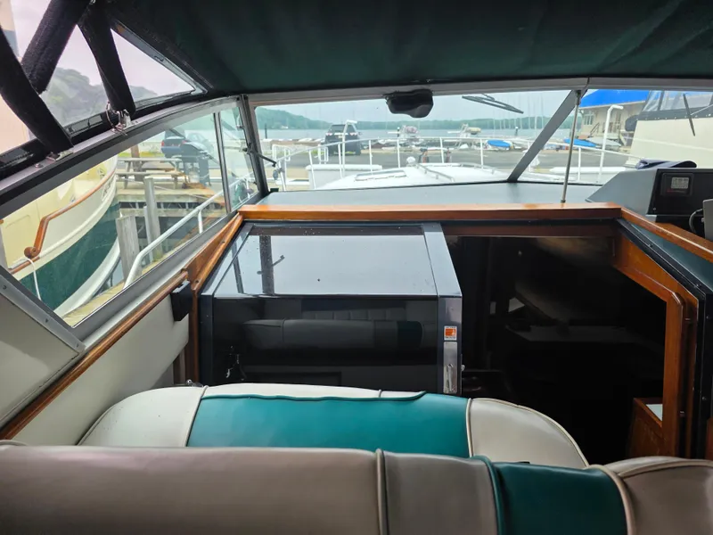 Slide: The Image of 1987 Sea Ray 390 Express Cruiser interior with green and white seating, docked at marina. - 13