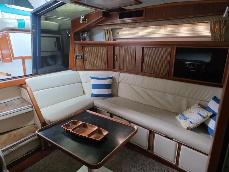 Slide: The Image of 1987 Sea Ray 390 Express Cruiser interior with cozy seating and nautical decor. - 18