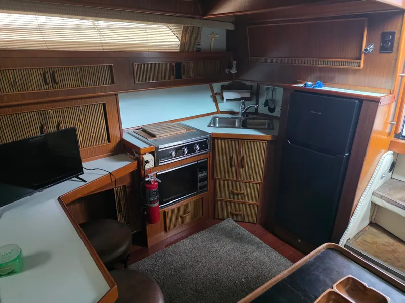 Slide: The Image of 1987 Sea Ray 390 Express Cruiser interior with kitchen, stove, sink, and refrigerator. - 19